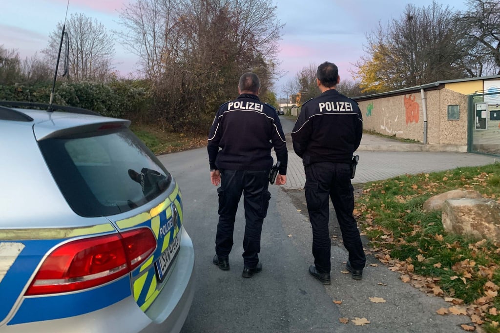 Zwei Polizisten stehen in der Nähe des Fundortes der toten 14-Jährigen.