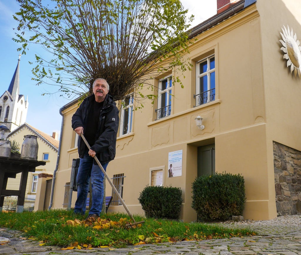 Manfred Fabian, Mitglied des Museums- und Heimatvereins Glinde beim Laubharken vor dem Museumshaus mit dem neuen Farbanstrich.