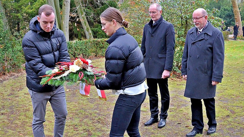 Andreas Dittmann und der Stdtratsvorsitzende Wilfried Bustro legen gemeinsam mit Franciceern einen Kranz nieder.