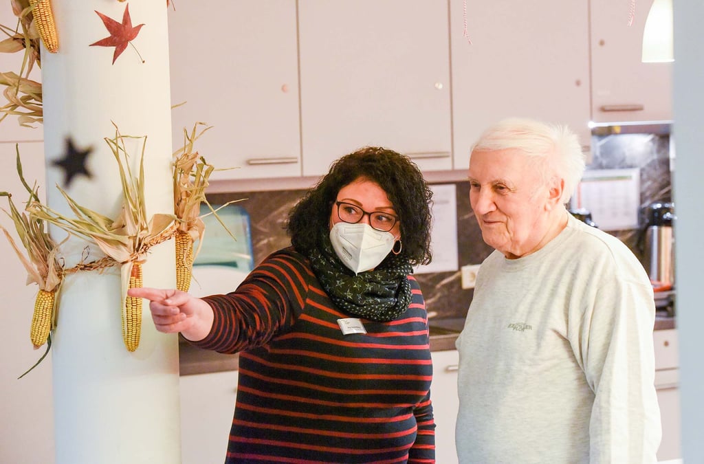Pflegerin Anja Dannenberg unterhält sich im Paul-Riebeck-Stift mit Bewohner Wolfgang Piske. Bewohner dürfen weiter Besucher empfangen.