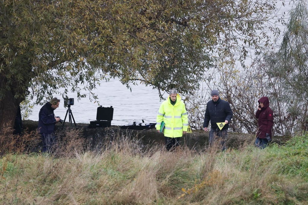 Polizisten suchen am Rheinufer im Stadtteil Niehl nach Spuren. Kurz nacheinander sind in einem Kölner Hafen und im Rhein eine Frauenleiche und ein totes Kind entdeckt worden.