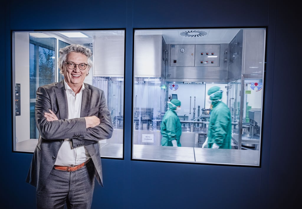Dermapharm-Chef Hans-Georg Feldmeier steht vor der neuen Abfüllanlage für den Corona-Impfstoff von Biontech. Die Produktion findet in einem Reinraum statt. Die dort tätigen Mitarbeiter müssen daher auch spezielle Schutzanzüge tragen.
