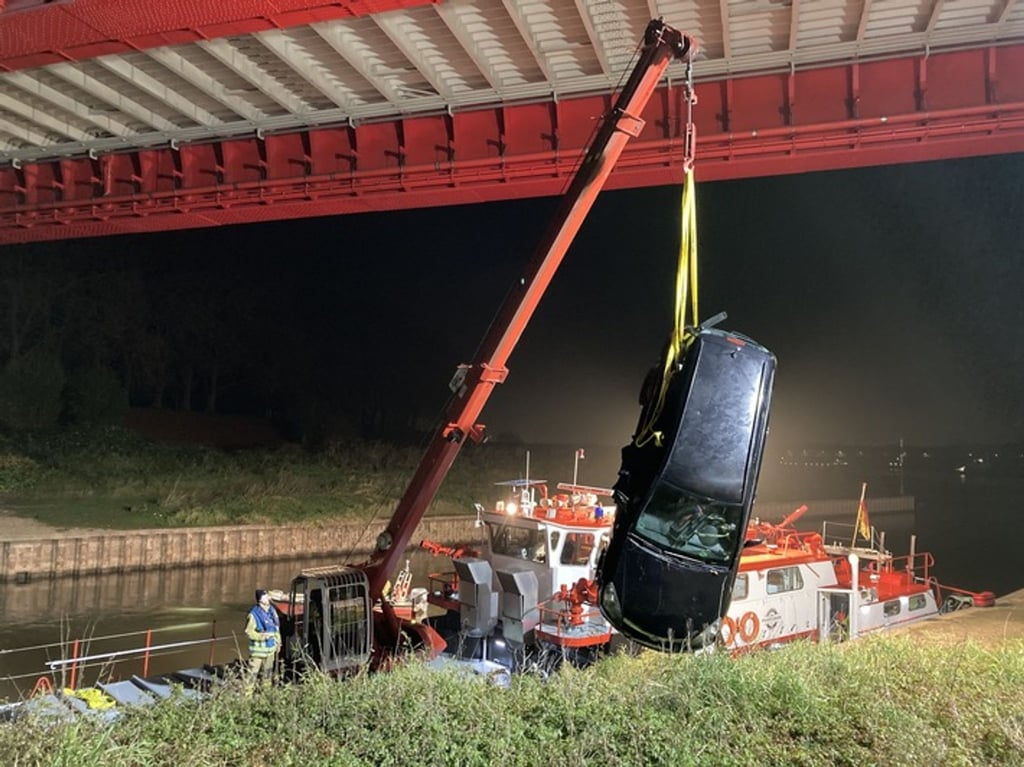 Das Auto eines Anglers wird am frühen Mittwochmorgen am Duisburger Hafen aus dem Wasser gezogen.