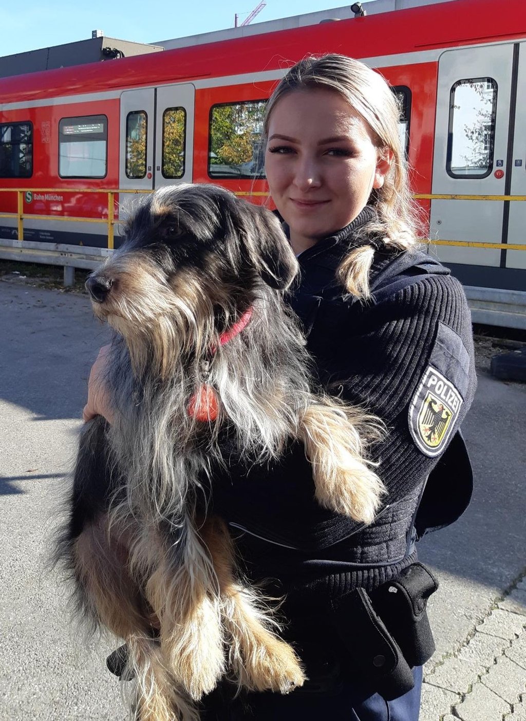 Der Rauhaardackel im Arm der Bundespolizistin Melanie.