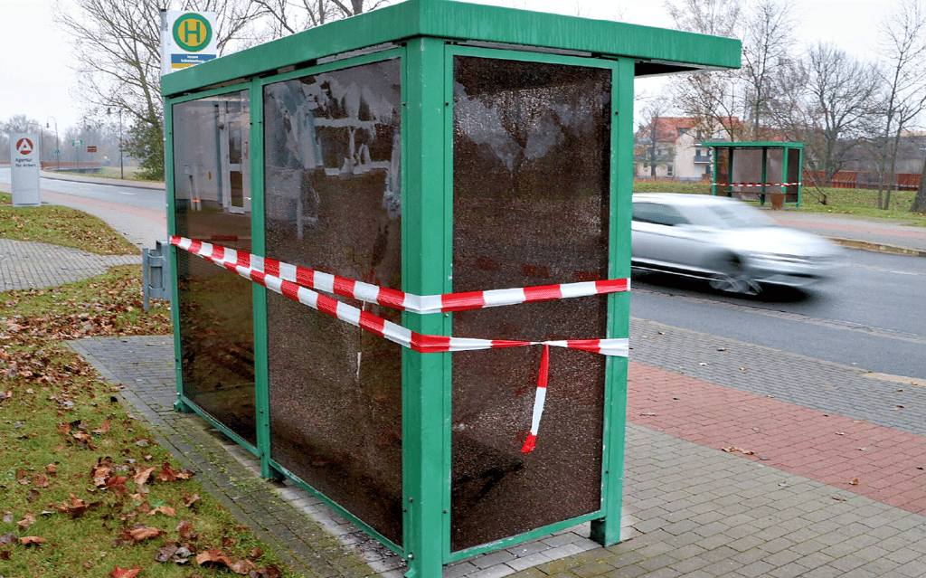 Die Scheiben eines Bushaltestellenhäuschens sind beschädigt