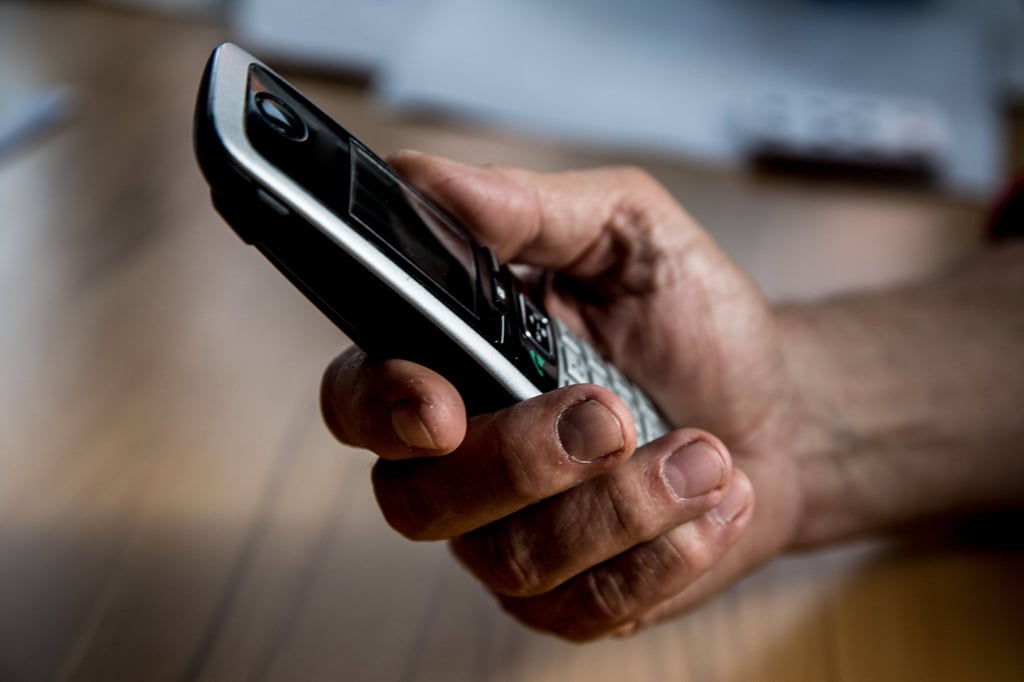 Ein Mann hält ein Telefon in der Hand.