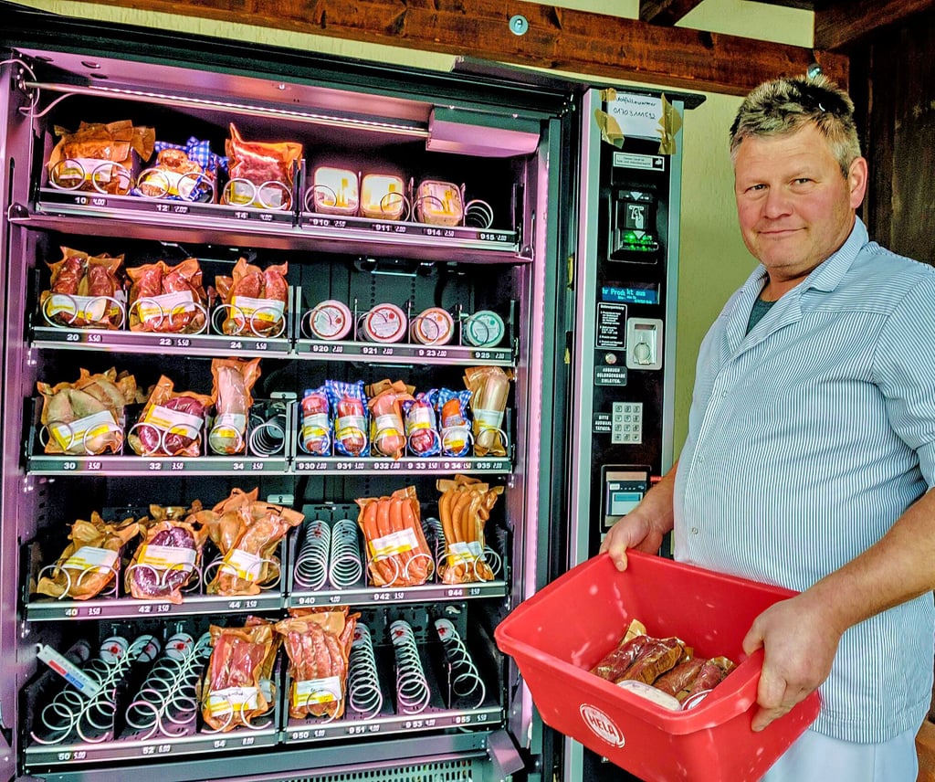 Fleischer Holger Freigang hat eine Kiste dabei. Darin befinden sich Wurstwaren und Metzgerprodukte, die er selbst in Bergwitz herstellt. Mehrmals täglich wird der Wurstautomat befüllt.