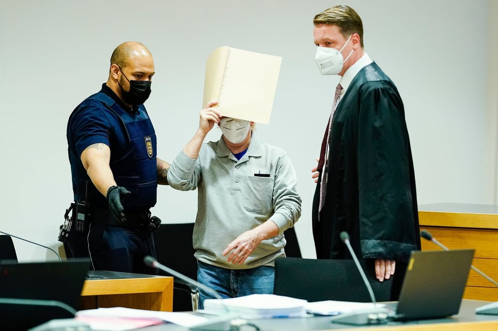 Der Angeklagte (M) mit seinem Anwalt Steffen Lindberg (r) und einem Justizbeamten zu Prozessbeginn im September im Gericht.