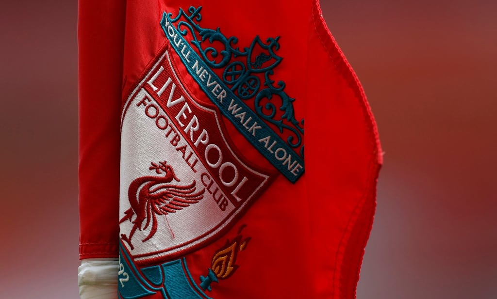 Das Wappen vom FC Liverpool mit der Aufschrift „You'll Never Walk Alone“ ist auf einer Fahne zu sehen.