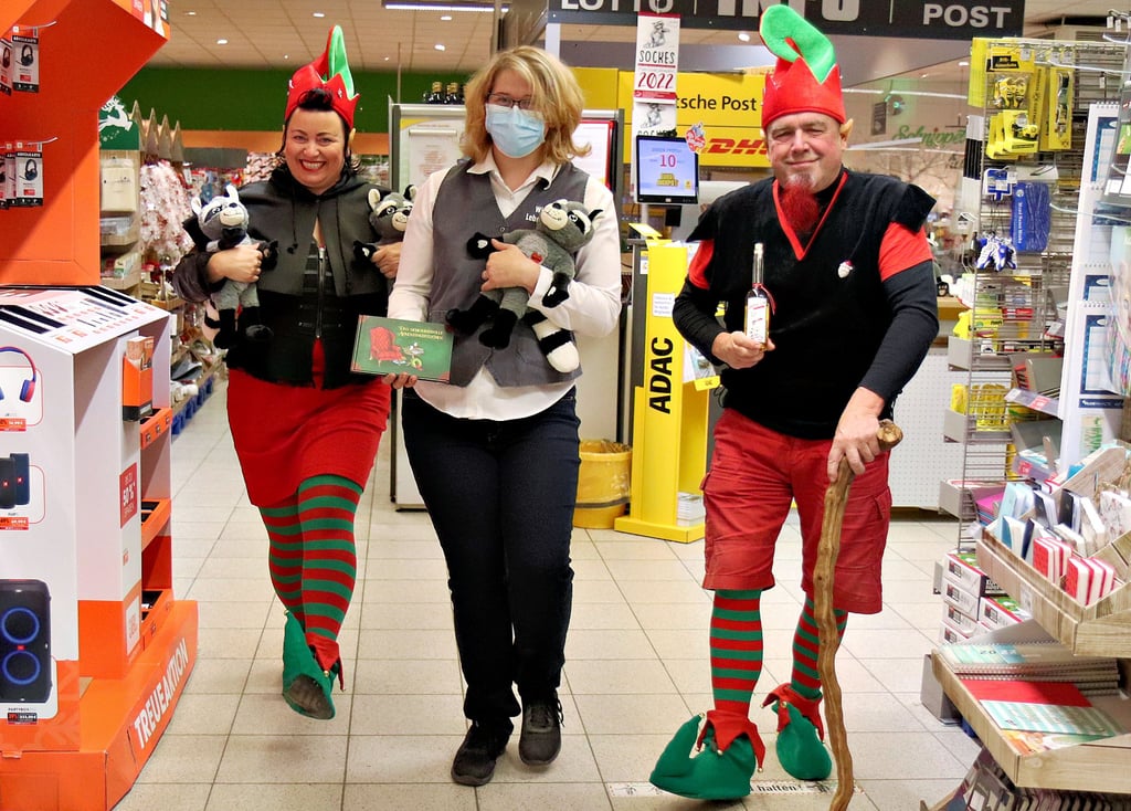 Katrin Packebusch, Maria Meier und Karsten Packebusch (von links) toben gut gelaunt durch den Edeka-Einkaufsmarkt von Dingelstedt. Mit dabei Waschbär Socke, das Maskottchen des Huylandverlages.
