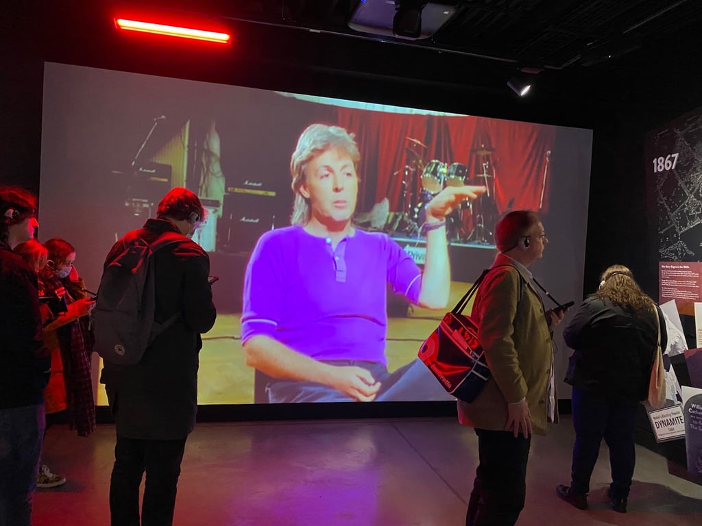 Studierende des Beatles-Studiengangs stehen in der Beatles-Installation von Strawberry Field.
