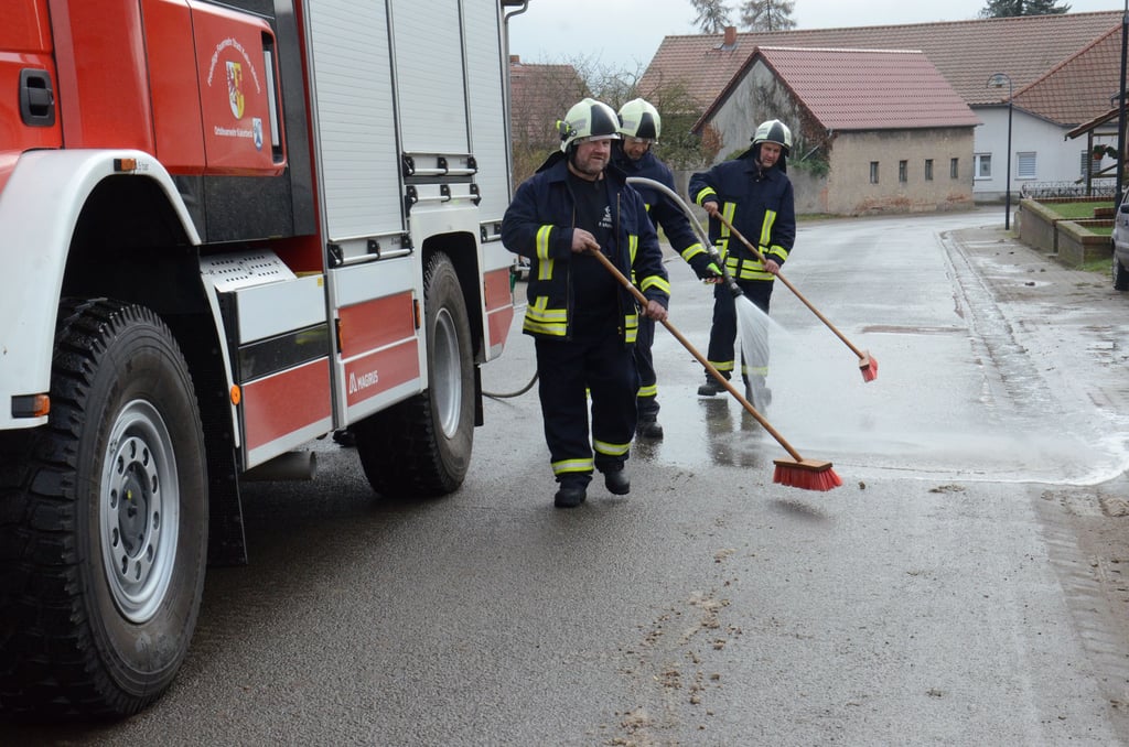 Mit Wasserstrahl und Besen beseitigen in Faulenhorst die Kameraden die Dämpfkartoffeln von der Straße.