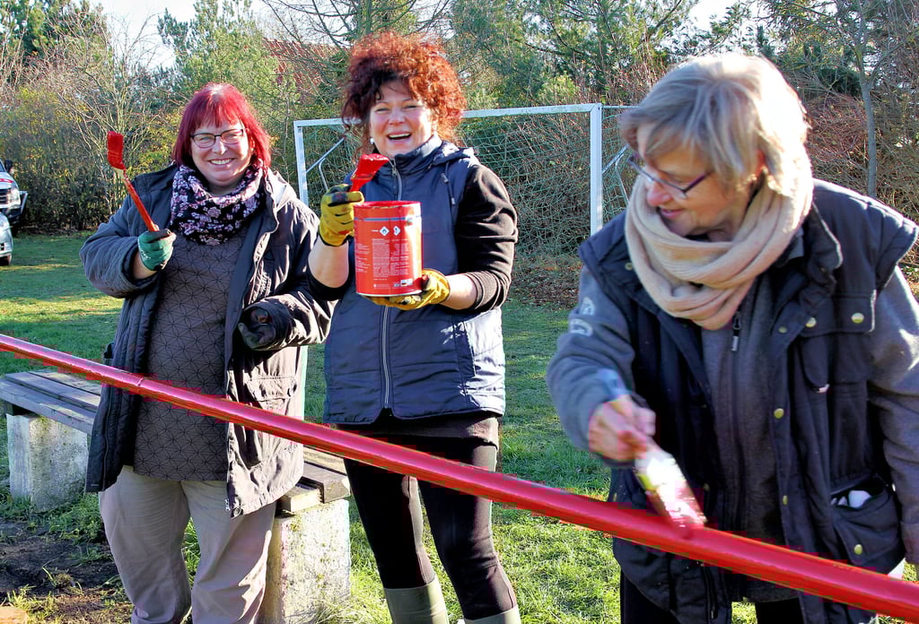 Auch das Geländer um den Sportplatz bekommt einen neuen Anstrich. Es hat eine Länge von über 500 Meter. Ein ganzes Stück Arbeit für Uta Bruhns (von links), Annerose Francke und Ute Schütte, die jedoch dank des strahlenden Sonnenscheins beim Streichen sichtlich ihren Spaß haben.