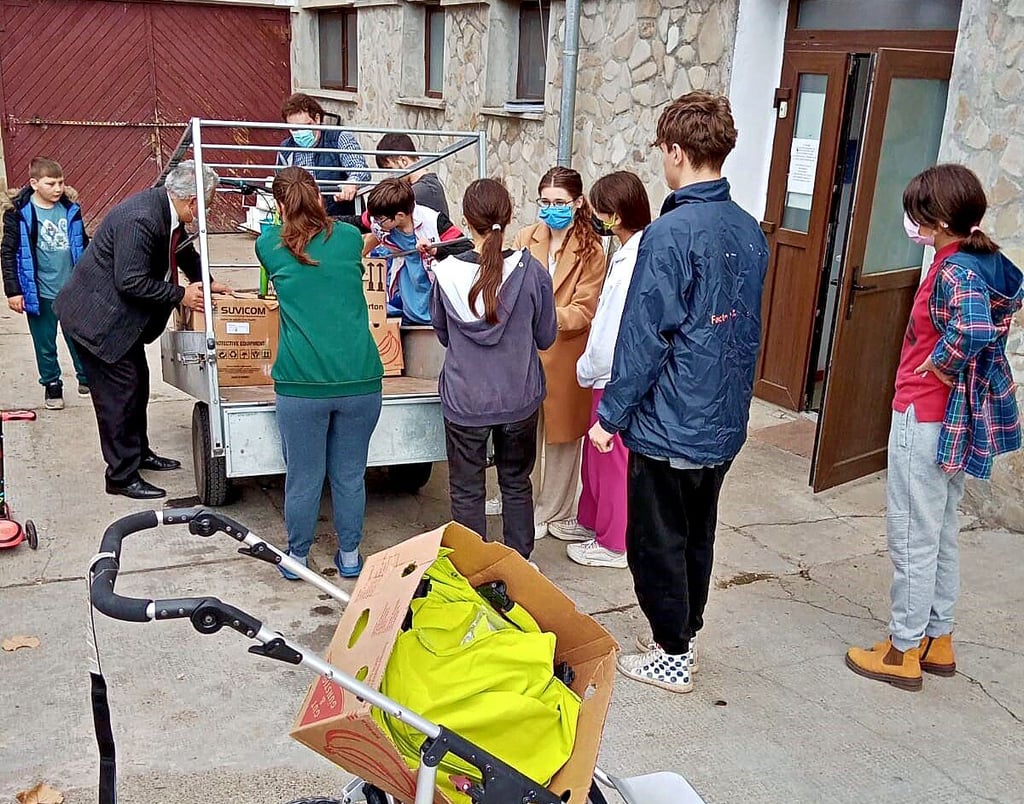 Vom Anhänger wird gerade ein Fahrrad geladen, sogar ein Kinderwagen ist dabei - Hilfsgüter aus Schönburg für das Waisenheim „Agape“ in Rumänien.