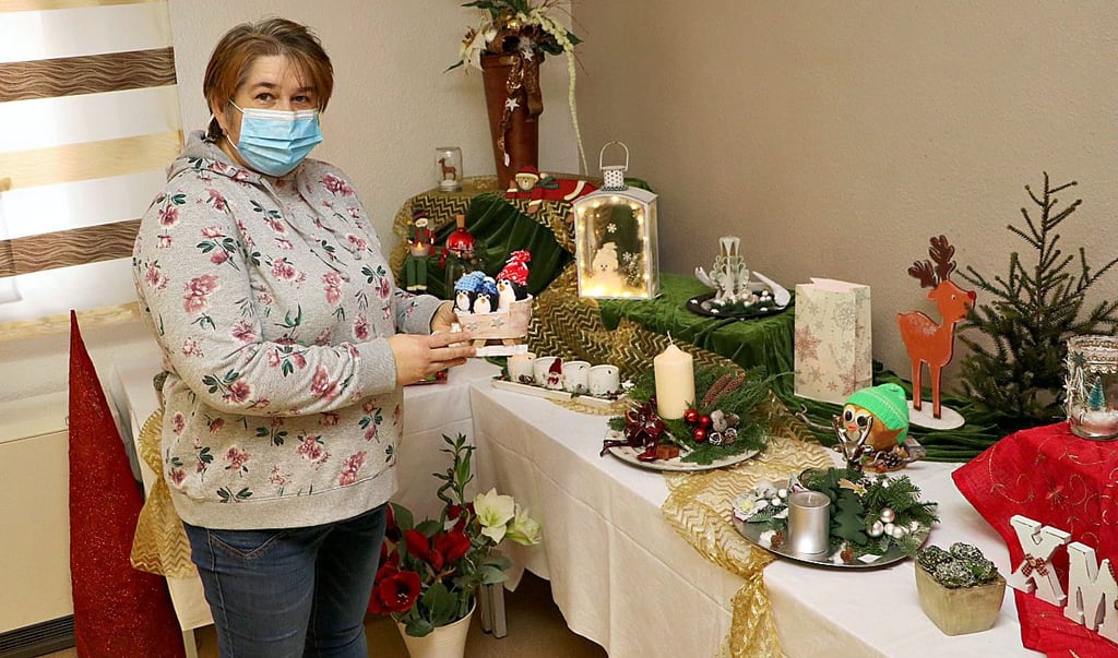 Elena Zeiser aus der Kreativwerkstatt vom „Wir“-Verein ordnet auf den Tischen an, was von Interessierten des Weihnachtsmarkts am Schwanenteich gekauft werden kann.