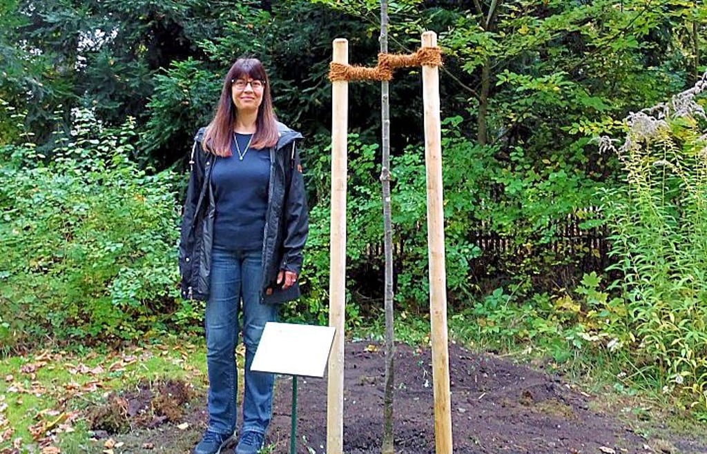 Katrin Eichenhard mit ihrer gespendeten Traubeneiche auf der Wiese am Nachtausgang.