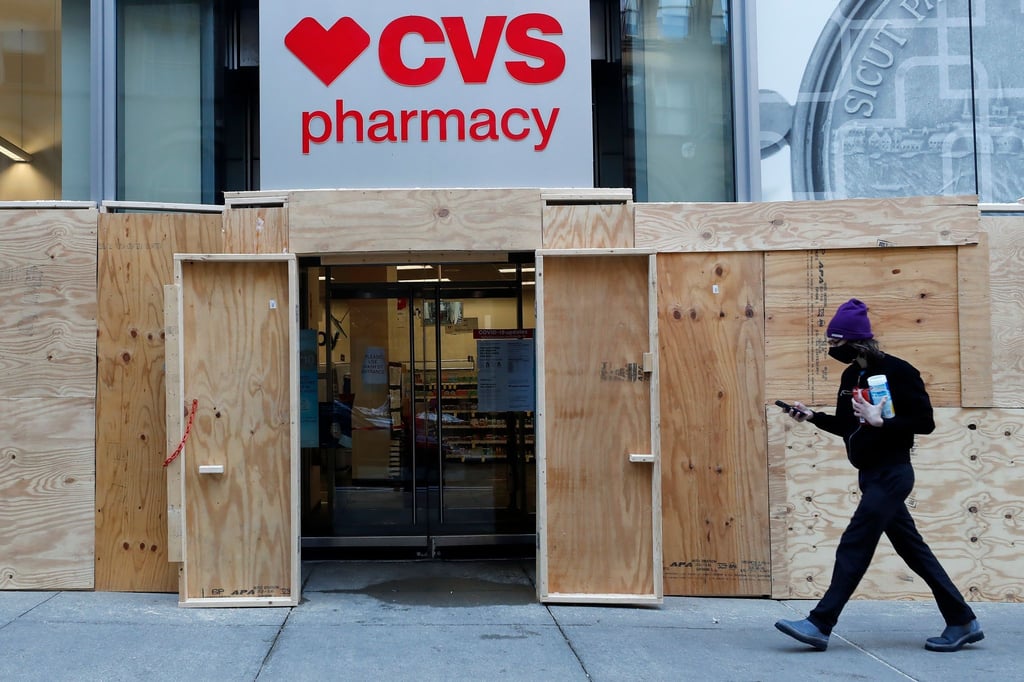 Ein Mann geht in Boston an einem mit Brettern vernagelten Geschäft der CVS-Apotheke vorbei. (Archivbild)