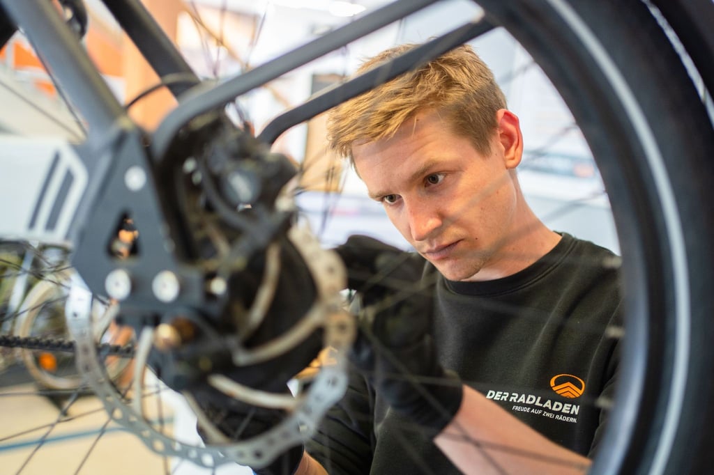 Im Februar hat er seine Ausbildung zum Zweiradmechatroniker abgeschlossen: Stefan Borschert setzt ein neues Hinterrad an einem E-Lastenrad ein.