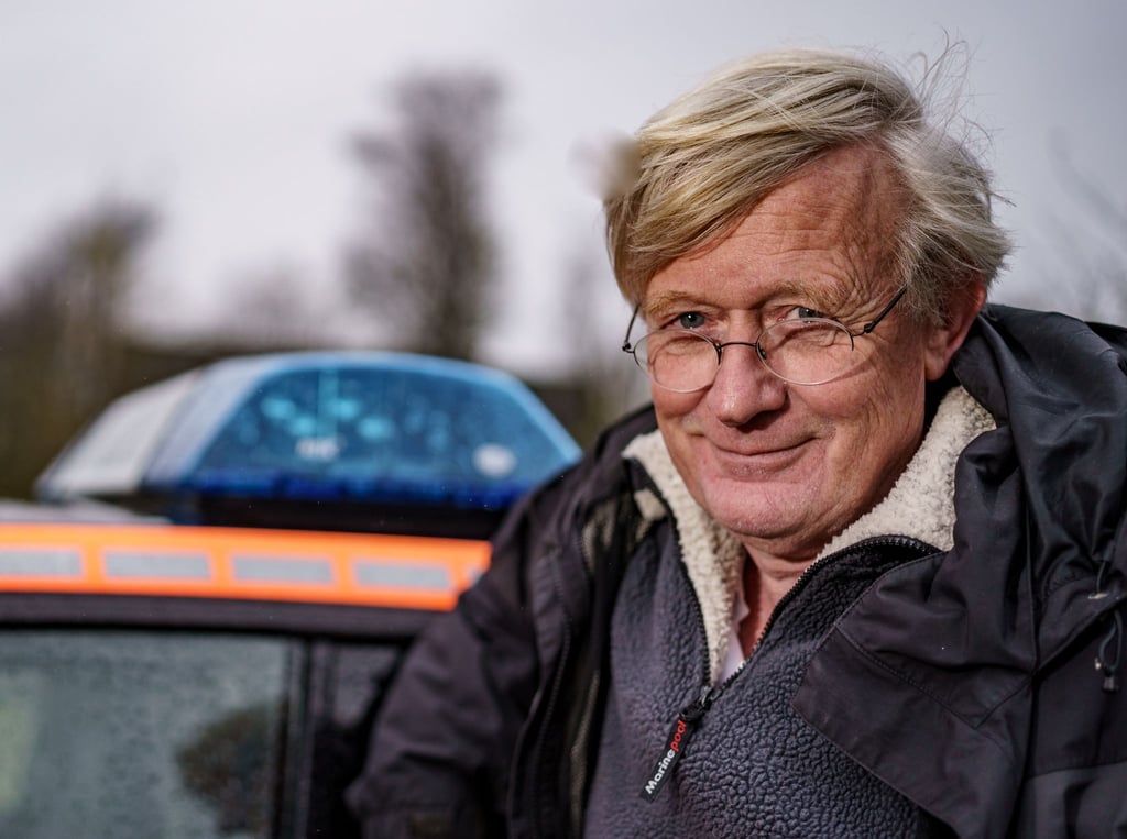 Inselarzt Rolf-Ferdinand Gehre neben seiner Praxis auf Pellworm am Notarztwagen.