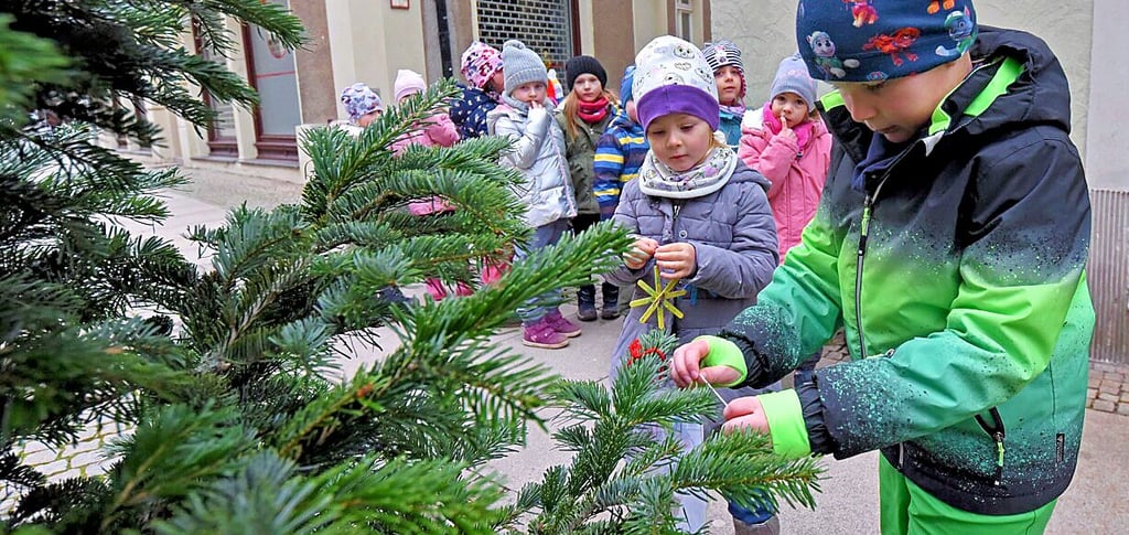 Die Fröbel-Kinder schmücken einen Baum in der Breiten Straße.