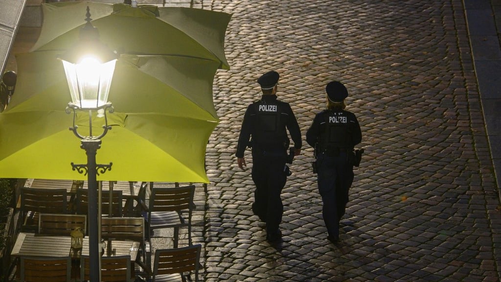 Polizisten gehen am Abend in der Dresdner Altstadt an Restaurants entlang. Die Polizeidirektion Dresden kontrolliert die Einhaltung der neuen Corona-Regeln täglich mit 50 Beamtinnen und Beamten. Im Fokus stehen demnach Kontrollen der FFP2-Maskenpflicht im öffentlichen Nahverkehr sowie die Ausgangsbeschränkungen für Ungeimpfte in Hotspot-Gebieten.