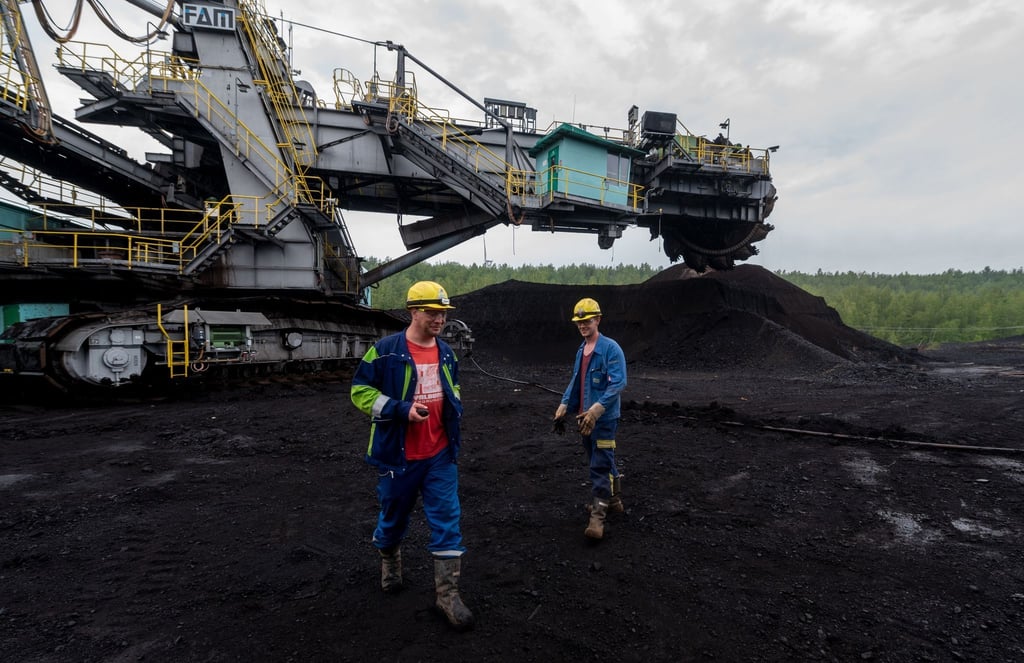 Kohle-Kumpel stehen im Tagebau Vereinigtes Schleenhain vor einem Bagger.