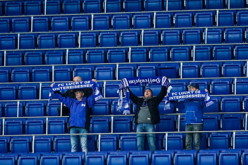Die Zugangsregeln bei der TSG 1899 Hoffenheim werden weiter verschärft: Fans halten vor leeren Zuschauerrängen ihre Schals in die Höhe.