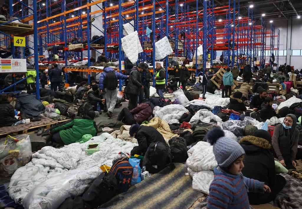 Migranten, die sich für die Nacht im Logistikzentrum am Kontrollpunkt „Kuznica“ an der belarussisch-polnischen Grenze einrichten.