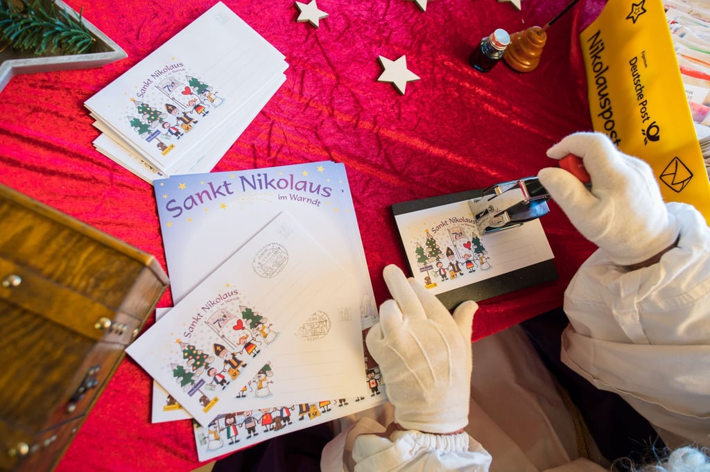 Der Nikolaus stempelt in der Nikolaushütte einen Brief ab.