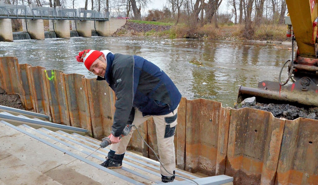 Heute sind die Bauarbeiten zur neuen Kanutreppe beendet. Bootsfahrer und andere Wassersportler können nun auch bequem unterhalb des Rothenförder Wehrs wieder einsetzen. Gestern wurde die Treppe noch mit einer Schutzvorrichtung versehen, während der Bagger den angeschwemmten Schlamm an der Spundwand beräumt.