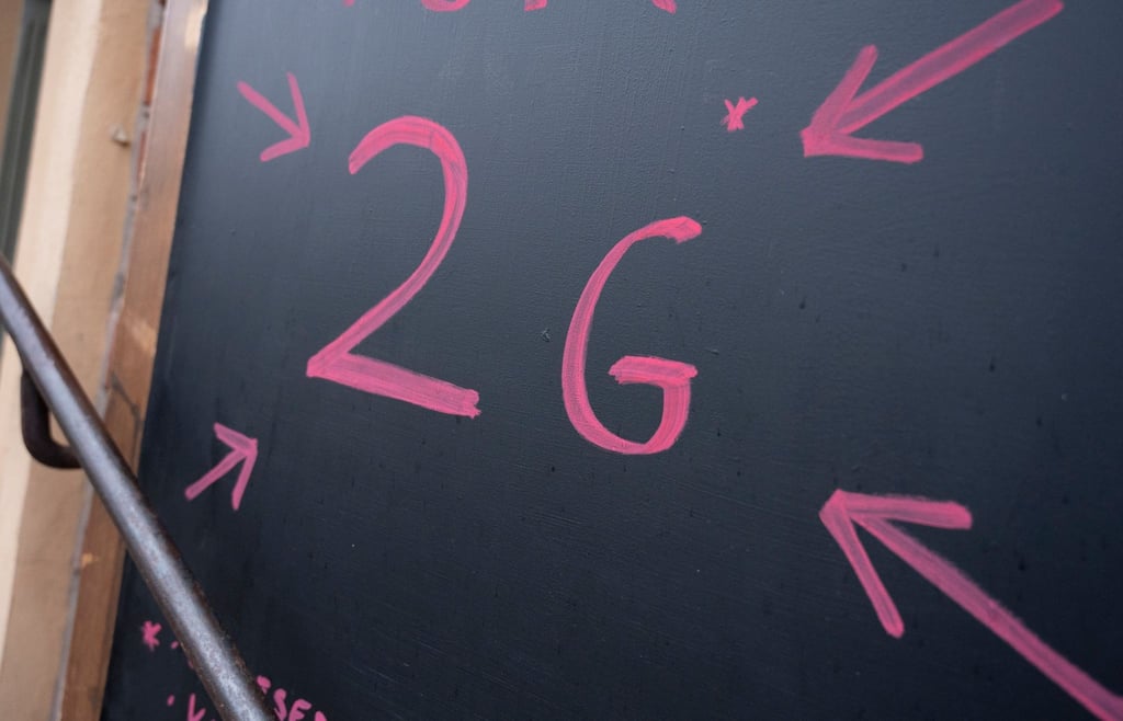 Ein Schild mit der Aufschrift „2G“ vor einem Geschäft in Potsdam.