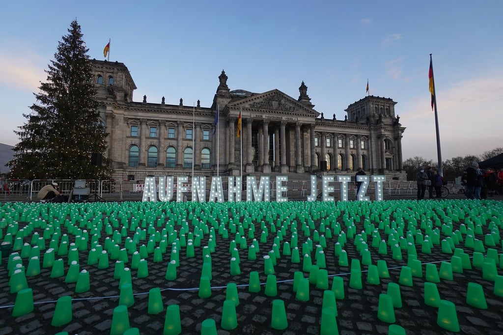 Ein Meer aus grünen Lichtern und der Schriftzug „Aufnahme Jetzt“ vor dem Reichstag in Berlin.