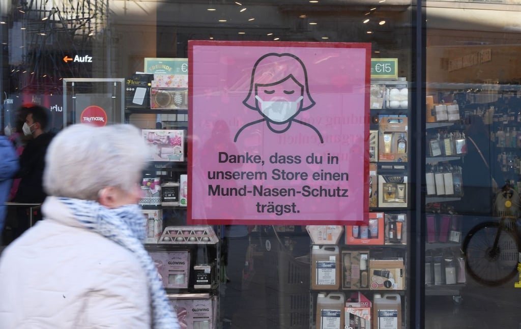 Illustration: Ein Schild am Fesnter eines Geschäfts weist auf die Maskenbpflicht hin.