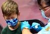 Ein Junge in den USA kneift während seiner Impfung die Augen zusammen. Nun könnte auch die EMA den Impfstoff empfehlen.
