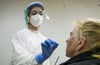 Eine medizinische Mitarbeiterin testet eine Frau auf das Coronavirus in einer Corona-Teststelle.