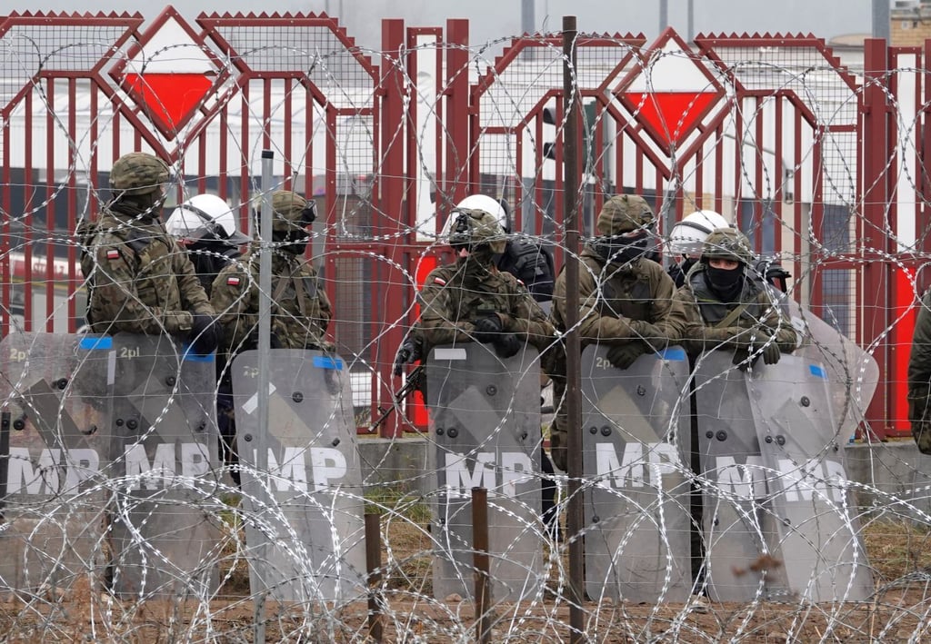Polnische Sicherheitskräfte stehen hinter dem Grenzzaun am Grenzübergang Brusgi (Belarus) und Kuznica (Polen).