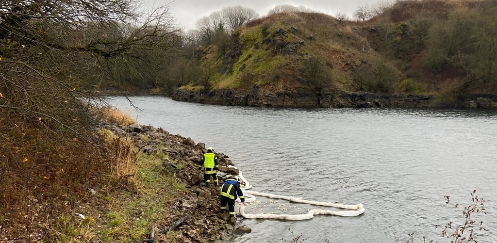 Die Feuerwehrleute errichten eine Ölsperre auf dem See am Tagebau Hornberg bei Elbingerode.