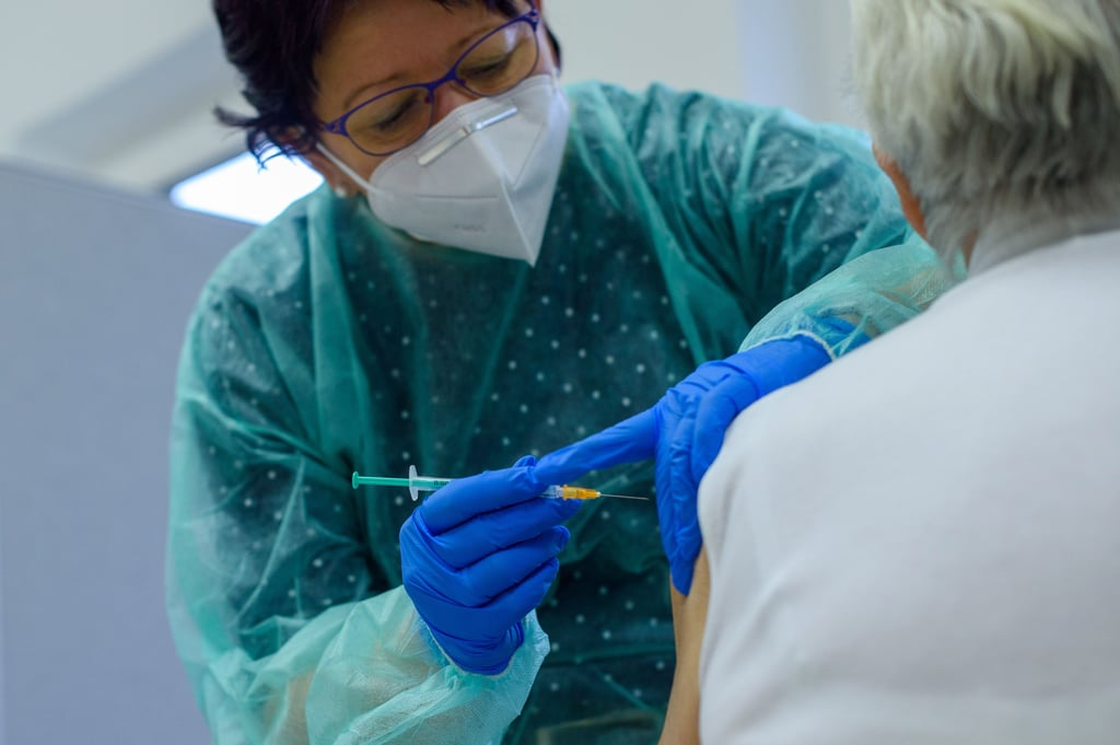 Eine Mitarbeiterin des Impfzentrums des Salzlandkreises spritzt einer Frau eine Impfdosis gegen das Coronavirus.