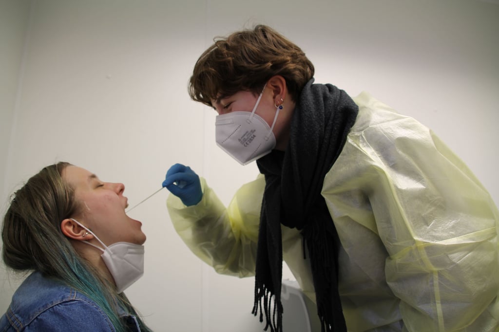 Eine junge Hallesnerin lässt im Test-Container an der Uniklinik einen Abstrich vornehmen.