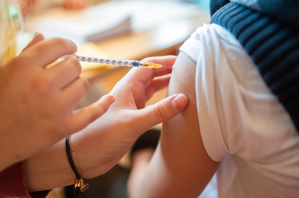 Ein Schüler bekommt eine Impfspritze in den Arm.