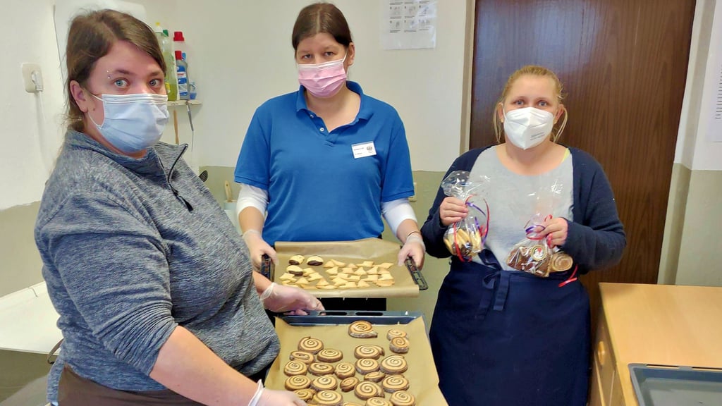 Anja Brabandt und Cornelia Kleiner (von links) zeigen Bleche mit frisch gebackenen Keksen und Plätzchen. Nicole Heidenreich (rechts) hält damit gefüllte Beutelchen für den Verkauf in den Händen.