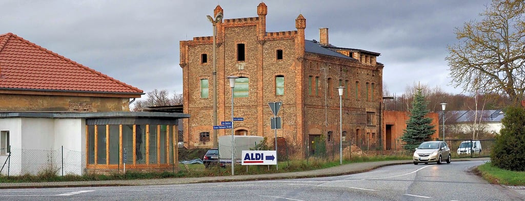 Das sind mehr oder weniger traurige Reste der Zuckerfabrik 25 Jahre nach dem Abriss. Links der Betriebseingang, bei dem jetzt aber eine Sanierung anlief, und dahinter die Investruine, die früher die Rübenwäsche beherbergt hat. Die Entwicklung dieses Gebietes blieb bis heute hinter den Erwartungen zurück.