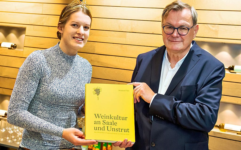 Knapp 300 Seiten stark und erfrischend gelb: Wieland Führs Buch zum Winzerfest. In Freyburg stellt er es mit Weinkönigin Luise Böhme vor.