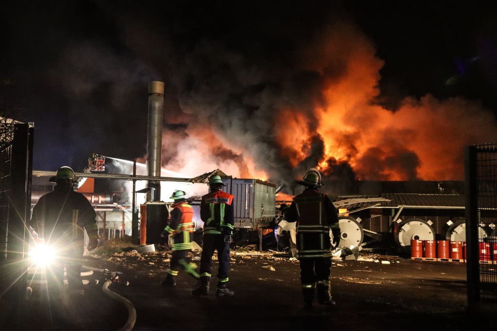 Feuerwehrleute löschen den Brand in einer Tapetenfabrik.