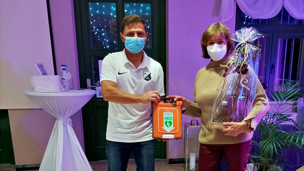 Sebastian Knobbe, Vorsitzender des SV Langenstein, bekommt von Annette Seelhorst einen Defibrillator.