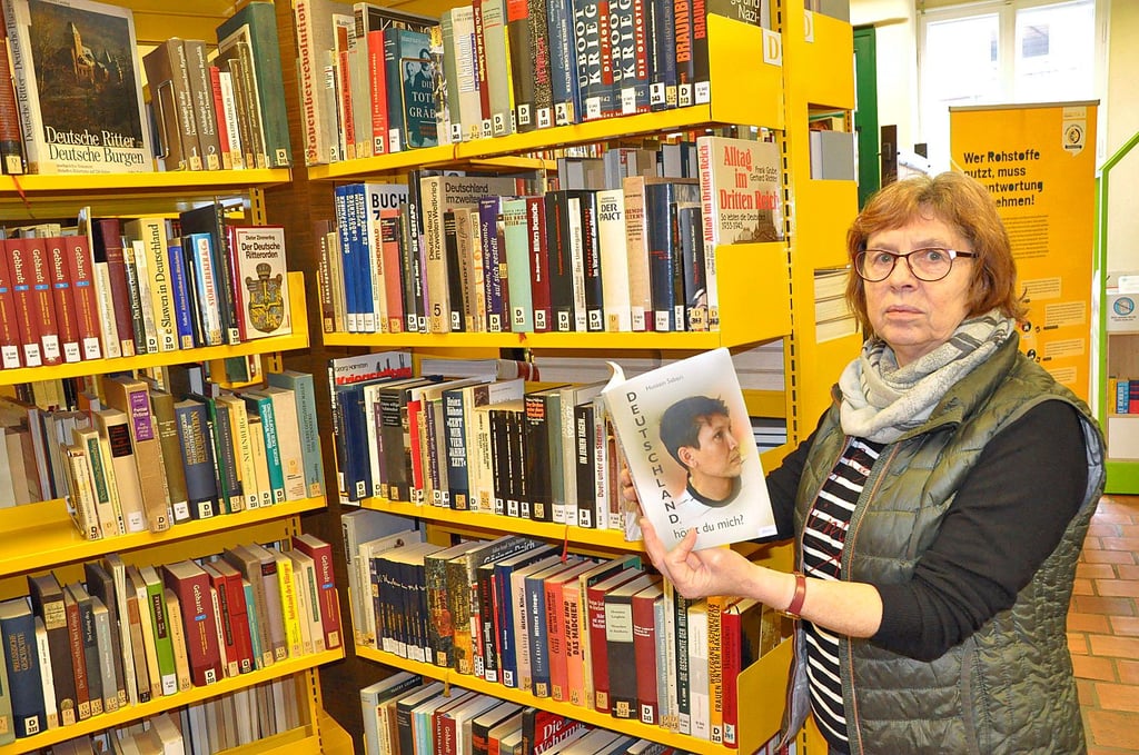 Burgs Bibliotheksleiterin Stefanie Göthe-Obieglo mit dem neuen Buch. Zusammen mit Autorin Dorothea Iser halt sie Hussain Saberi bei der Zusammenstellung.