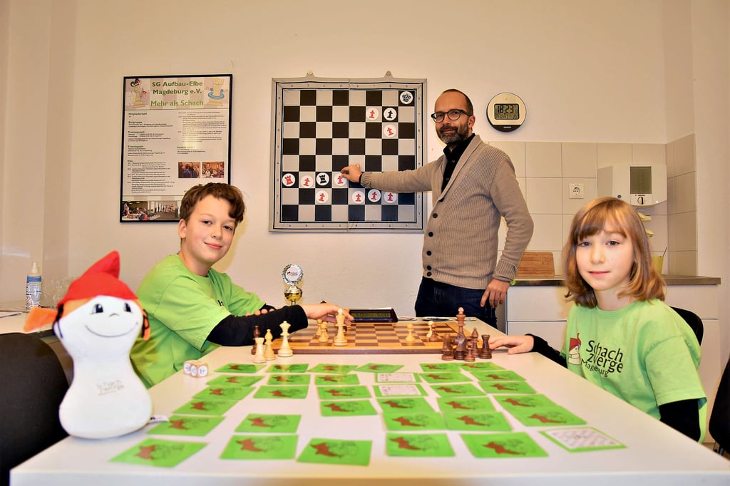 Der Geschäftsführer der Schachzwerge Magdeburg, Michael Zeuner, hat für die jungen Schachtalente Lotte und Jakob eine Aufgabe vorbereitet.
