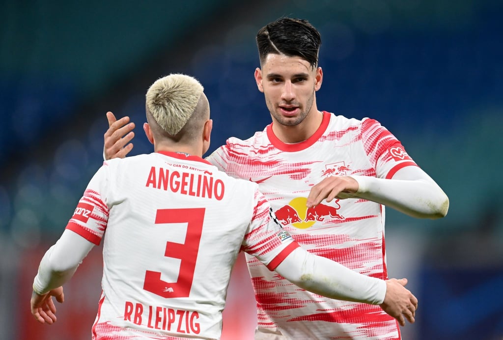 Leipzigs Angelino (l) und Dominik Szoboszlai jubeln nach dem Spiel.