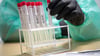 Proben für einen PCR-Test werden von einem Mitarbeiter in einem Corona-Testzentrum sortiert.  Fällt ein solcher PCR-Test bei einer Person im Salzland positiv aus, muss diese nicht nur ihre Kontakte bennenen und an das Gesundheitsamt übermitteln, sondern diese auch selber benachrichtigen.  