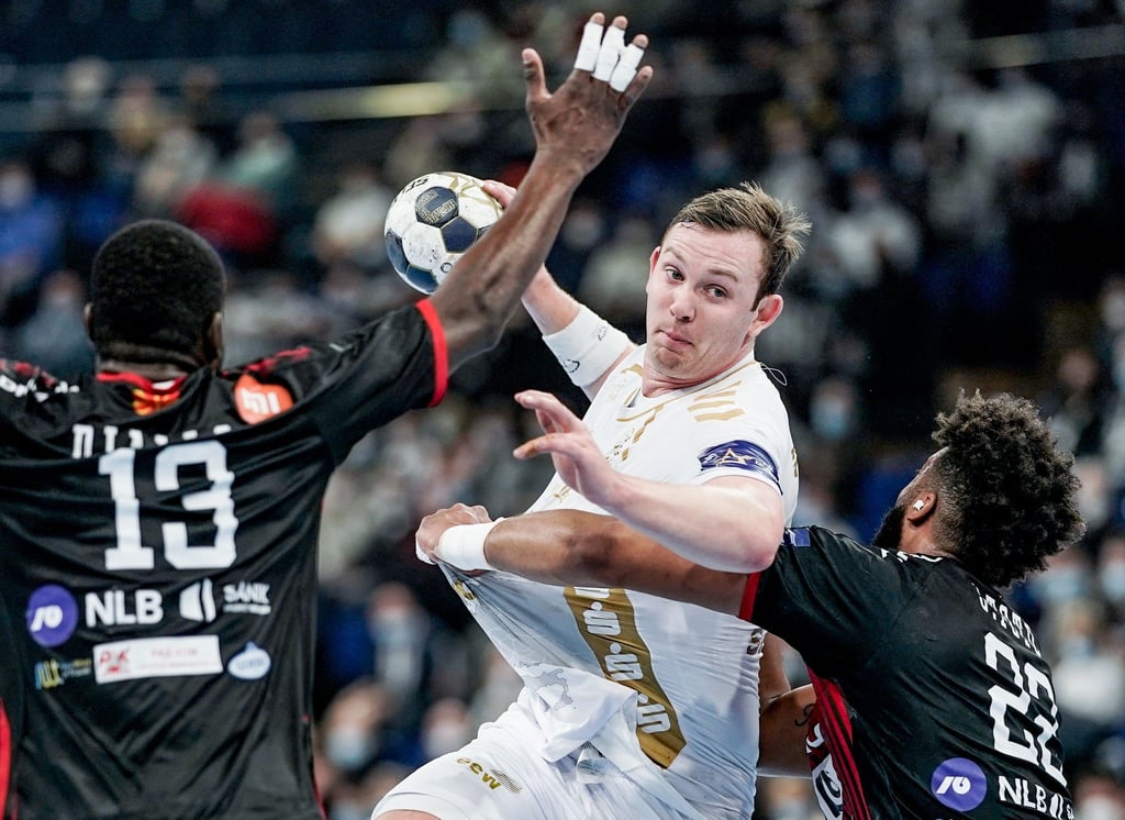 Sander Sagosen (M) vom THW Kiel setzt sich am Wurfkreis gegen Skopjes Bakary Diallo (l) und Jeremy Toto durch.